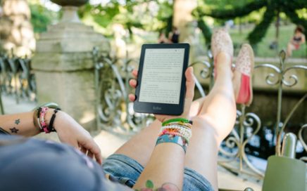 Woman reading a Kobo eReader on holiday